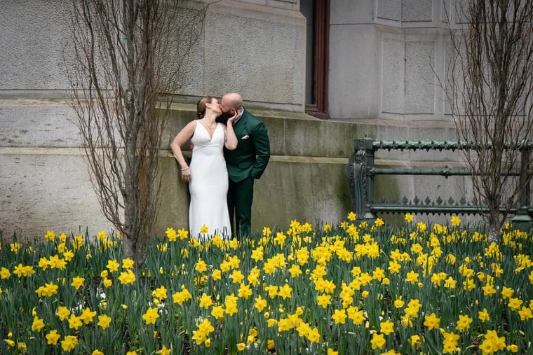 Newly married Elisha and Brad Cook participate in a photoshoot with their photographer (not shown) amidst blooming flowers, in front of City Hall, in Philadelphia. The couple was married yesterday at City Hall.