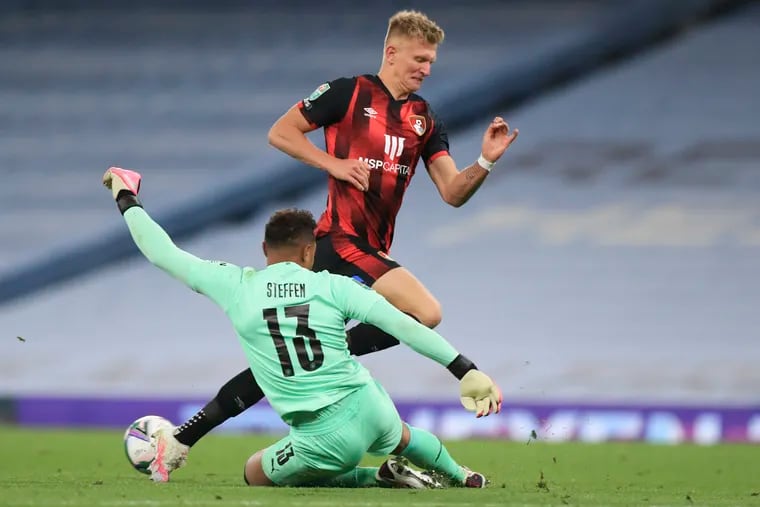 Zack Steffen slides to kick the ball away from Bournemouth's Sam Surridge during Thursday's Carabao Cup game.