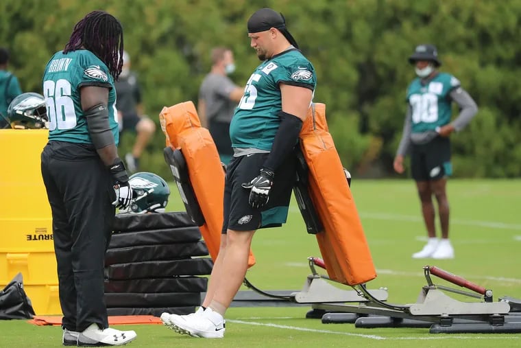 Lane Johnson (right) chats with new Eagles offensive lineman Jamon Brown at Thursday's practice.