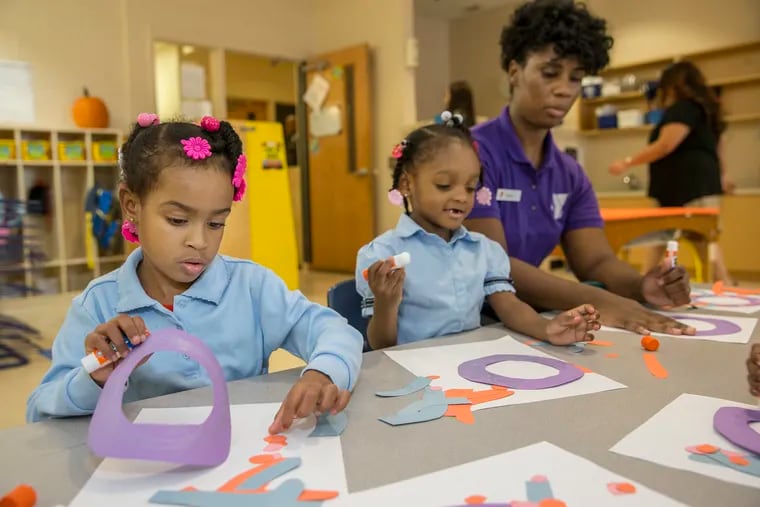 Lyriq Brooks, 4, left, and Ceyanee Brown, center, 4, work with their Pre-K teacher Shannon Hurley, right, in the Pre-K classroom at the Columbia North YMCA, gluing paper cutouts to make an octopus on October 20, 2016.