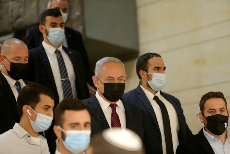Israeli Prime Minister Benjamin Netanyahu, center, arrives at the Israeli Knesset (Parliament) ahead of a vote to dissolve the Knesset, in Jerusalem, Wednesday, Dec. 2 2020. The Israeli parliament passed a preliminary proposal to dissolve itself on Wednesday, setting up a possible fourth national election in under two years while the country is in the grip of the coronavirus pandemic.