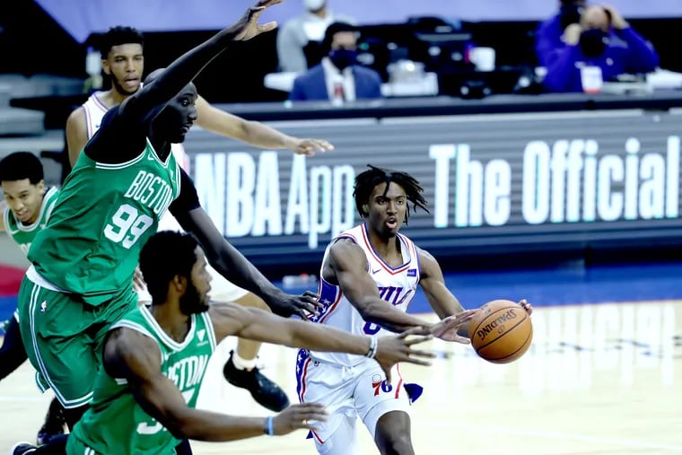Tyrese Maxey, right, of the Sixers passes to a teammate around the defense of Tacko Fall, left, and Semi Ojeleye of the Celtics during the fourth quarter of Tuesday's game at the Wells Fargo Center.