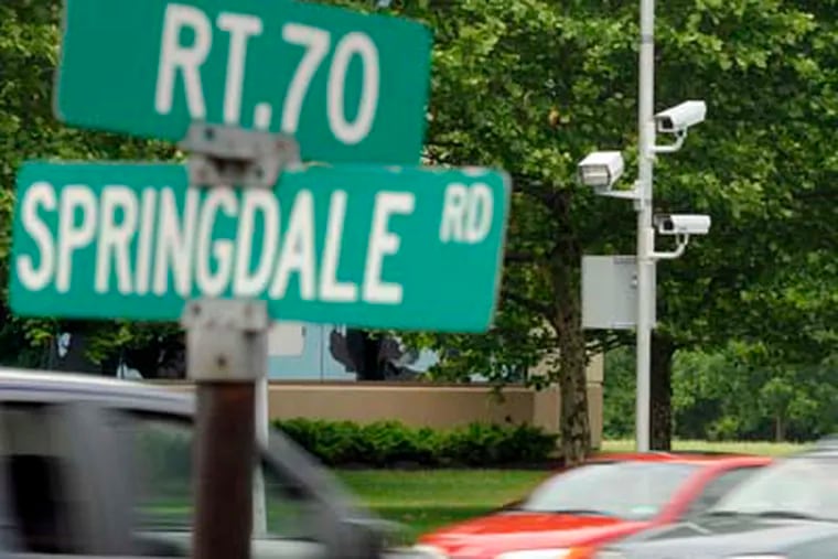 Red-light cameras (right) are mounted on eastbound Route 70, at Springdale Road in Cherry Hill. ( TOM GRALISH / Staff Photographer )