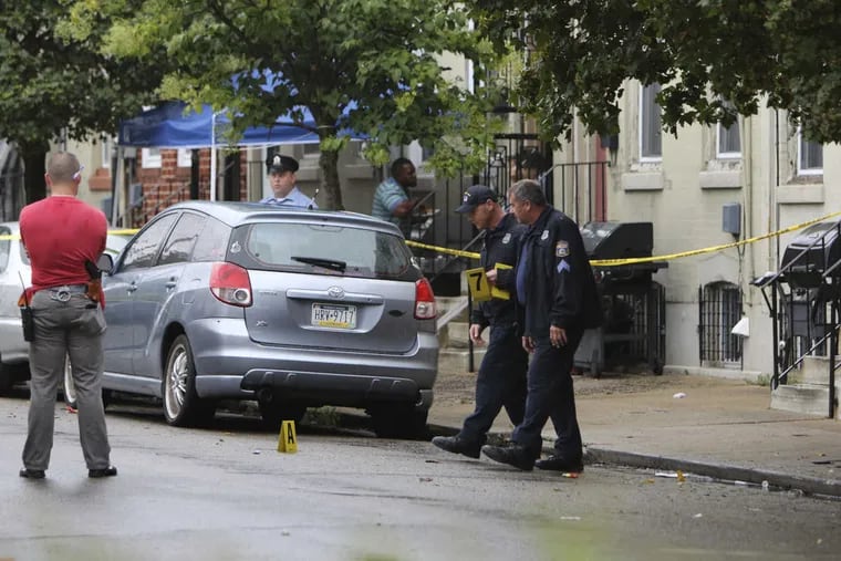 Police investigate the crime scene on Fairhill Street near Diamond Street, Monday, Aug. 7, 2017, after Philadelphia police officers shot a man they say pointed a handgun at two officers who responded to a "person with a gun" call shortly after 4:30 p.m. Monday, according to police.