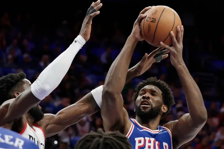 Sixers center Joel Embiid is fouled by Portland's Deandre Ayton on Sunday.