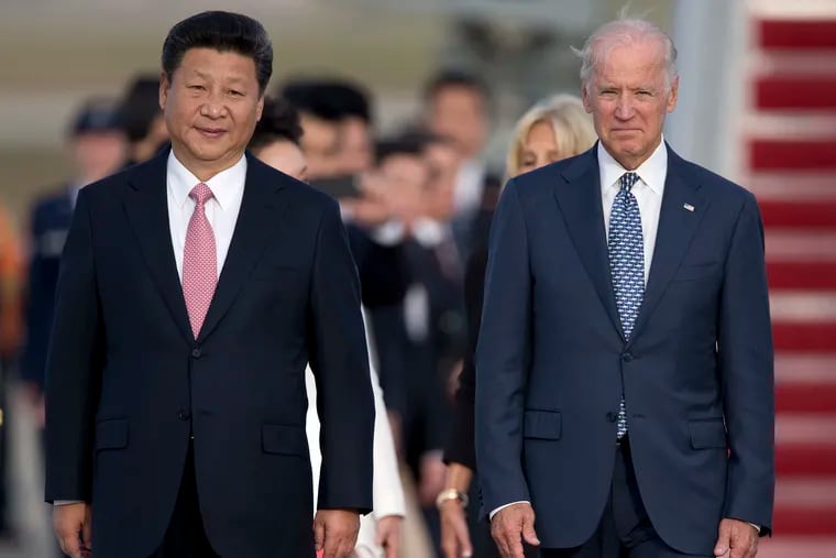 Chinese President Xi Jinping and Vice President Joe Biden walk down the red carpet on the tarmac during an arrival ceremony in Andrews Air Force Base, Md. in September 2015.