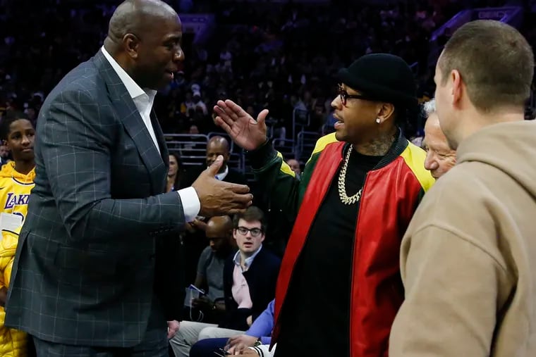 Allen Iverson (right) greats Magic Johnson during Sunday's star-studded game.