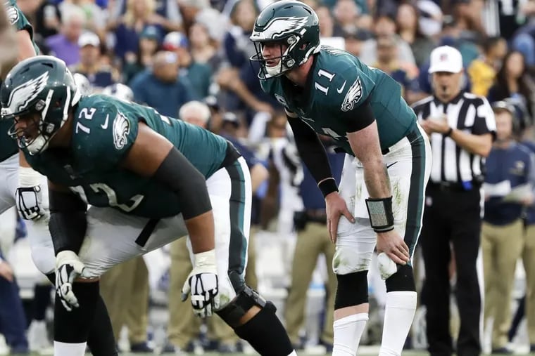 Eagles quarterback Carson Wentz rubs his knee before the Eagles scored in the third-quarter against the Los Angeles Rams on Sunday, December 10, 2017. YONG KIM / Staff Photographer