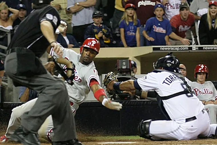 The Phillies' Jimmy Rollins scores as Padres catcher Yorvit Torrealba misses the tag. (AP Photo/Gregory Bull)