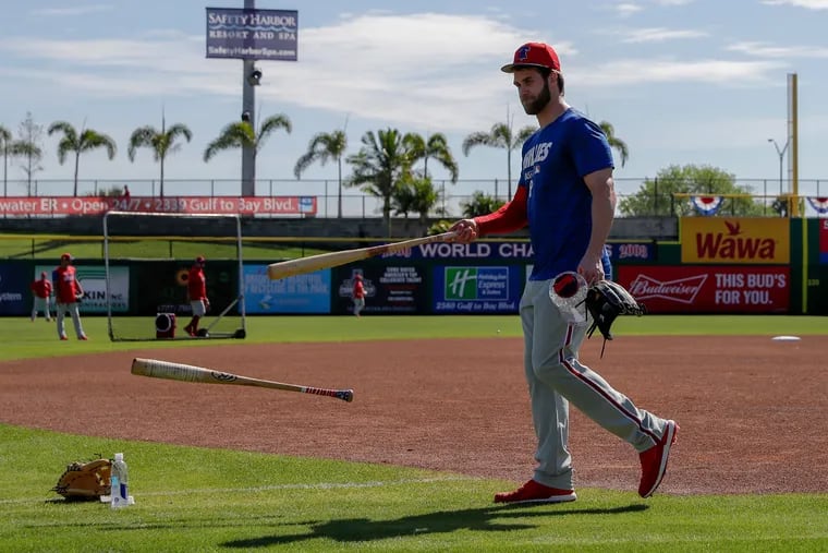 Bryce Harper tossing his bats after batting practice Sunday.