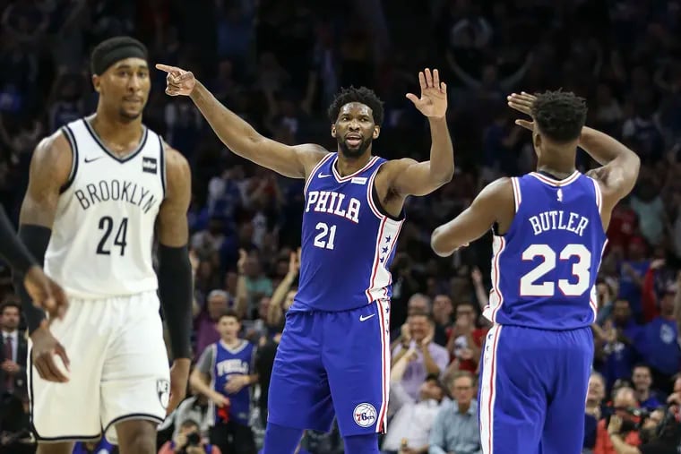 Sixers' Joel Embiid celebrates with Jimmy Butler in front of  Nets' Rondae Hollis-Jefferson during the 2nd quarter of Game 5 of the first round of the NBA playoffs at the Wells Fargo Center in Philadelphia, Tuesday, April 23, 2019.
