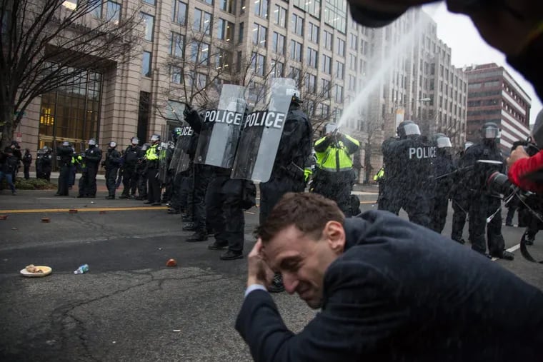 Police spray pepper spray into a line of photojounalists during clashes at a protest during the inauguration of Donald Trump January 20th 2017.