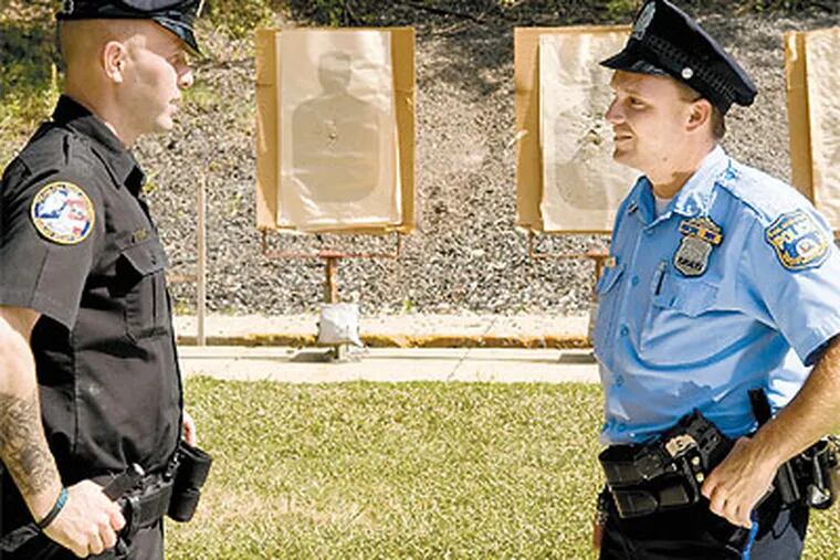 Officer Richard Hayes (left) with fellow officer George Higginson Thursday at Police Academy. (Kriston J. Bethel / Staff Photographer)