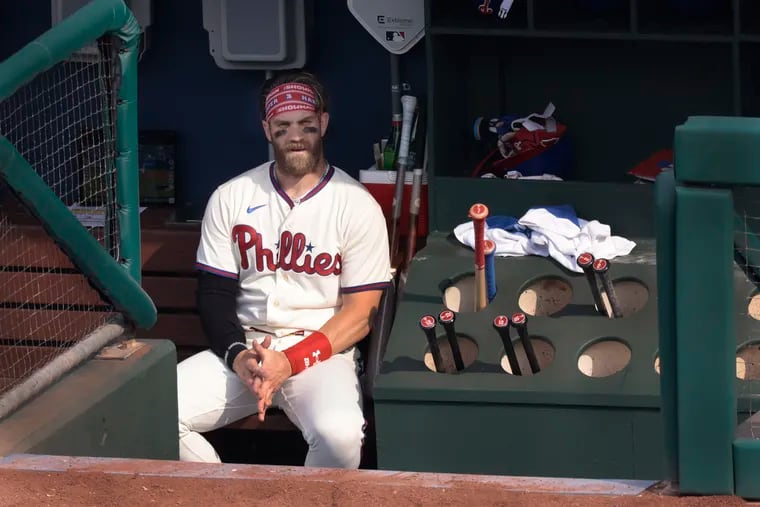 Bryce Harper sits in the dugout earlier this June.