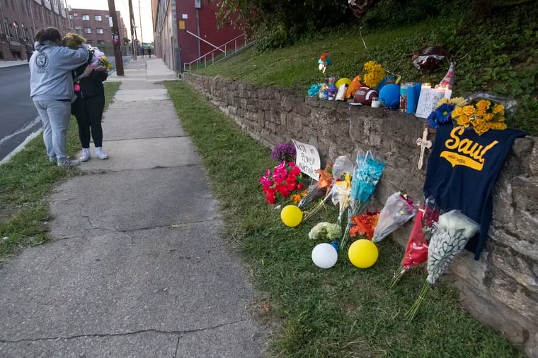 A vigil was held in Gorgas Park in Roxborough on Sept. 29, 2022, for Nicolas Elizalde, who was fatally shot near the Roxborough High School football field and Gorgas Park. Two women embrace by the memorial near the location of the shooting on Pechin Street.