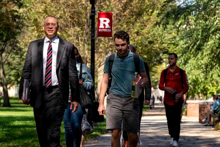 Rutgers University President Jonathan Holloway (left) walks across campus with students and staff after hosting a Byrne Seminar called "Citizenship, Institutions, and the Public" at Rutgers–New Brunswick in 2023.  Holloway will testify before a congressional committee Thursday on his handling of antisemitism and speech related to the war in Gaza.