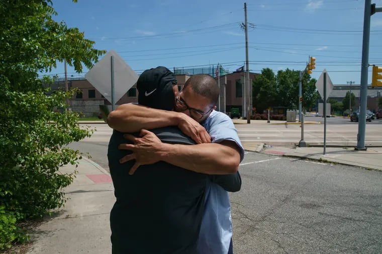 Terrance Lewis, center facing camera, receives a hug from his father Michael Lewis, after getting out of prison in Chester, May 22, 2019.