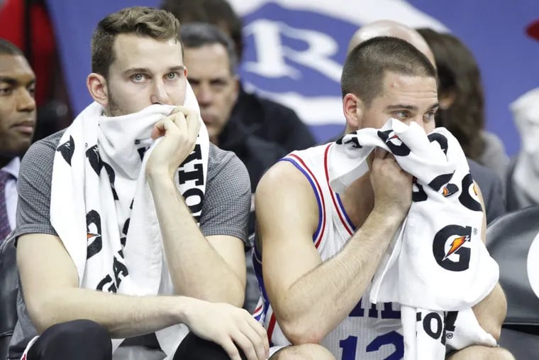 Sixers Nik Stauskas (left) and T.J. McConnell look dejected on the bench during a game in November 2015.