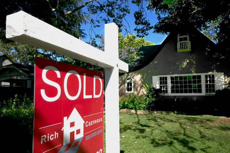FILE photo shows a "Sold" sign displayed in front of a house.