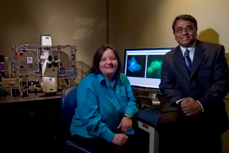 Doctors Sigrid A. (left) and Ayyappan K. Rajasekaran, with the Nemours Center for Childhood Cancer Research in Wilmington (he's the director) sit in a high tech lab with a new, unique high-resolution microscope (left) that studies cell surfaces.  On the computer monitor are images of cells that are being studied/researched into how best to avoid cancer cell migration and metastasis.  ( Clem Murray / Staff Photographer )