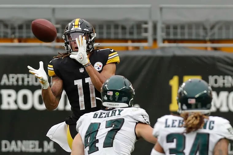 Steelers wide receiver Chase Claypool watches the football into his hands as Eagles linebacker Nate Gerry and cornerback Cre'von LeBlanc watch Claypool score a 35-yard touchdown to seal the victory.