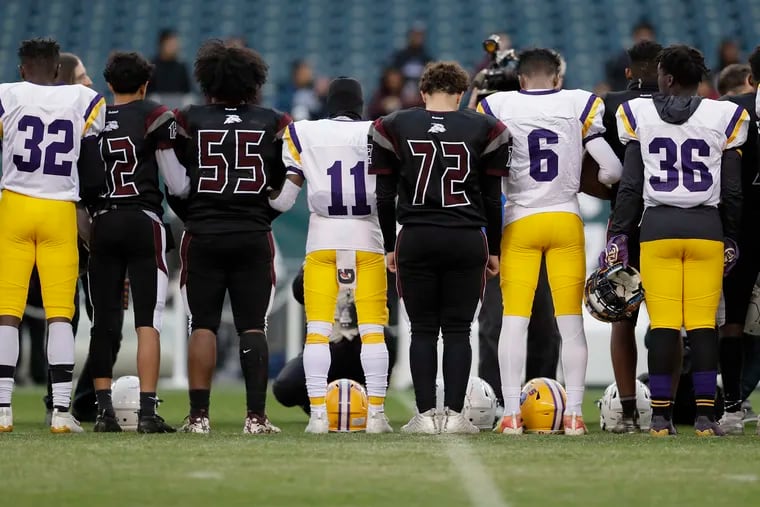 Camden (white jerseys) and Pleasantville players have a moment of silence befiore the Pleasantville vs Camden H.S. football game at Lincoln Financial Field in Phila., Pa, on November 20, 2019. This was the resumption the game at Pleasantville H.S. that was stopped last Friday because of a shooting in the stands. Camden won 22-0.