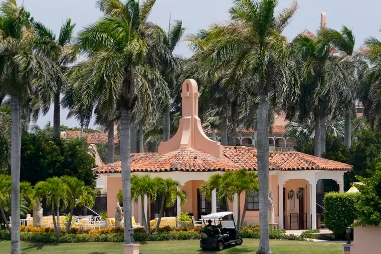 Security moves in a golf cart at former president Donald Trump's Mar-a-Lago estate on Tuesday in Palm Beach, Fla.