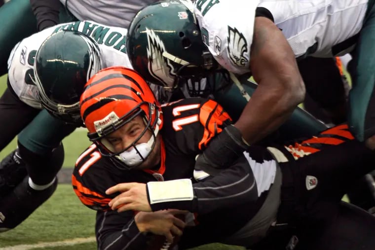 Ryan Fitzpatrick, as a Bengal, gets taken down by former Eagles Darren Howard (left) and Victor Abiamiri during a November 2008 game that ended in a tie.