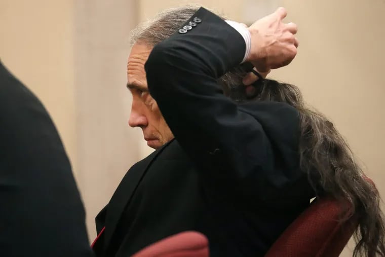 Ferdinand Augello puts his hair in a ponytail as his trial begins at the Atlantic County Justice Facility in Mays Landing, Monday, Sept. 17, 2018.