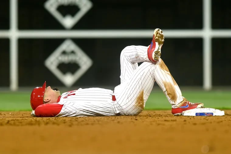 Rhys Hoskins rests at second base after spraining his ankle during Monday night's loss to the Mets.