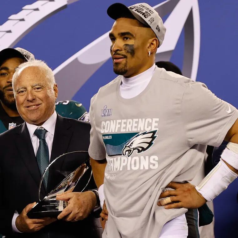 Eagles quarterback Jalen Hurts with Chairman and Chief Executive Officer Jeffrey Lurie holding the NFC Championship trophy.