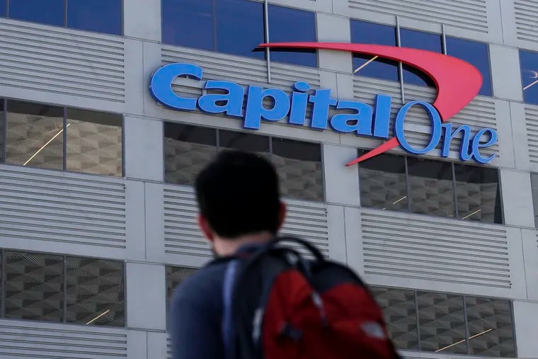 In this July 16, 2019, photo, a man walks across the street from a Capital One location in San Francisco. Capital One says a hacker got access to the personal information of over 100 million individuals applying for credit. The McLean, Virginia-based bank said Monday, July 29, it found out about the vulnerability in its system July 19 and immediately sought help from law enforcement to catch the perpetrator.