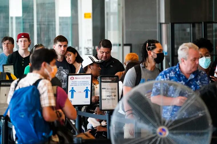 Travelers wait in a security line at the Philadelphia International Airport ahead of the Independence Day holiday weekend in Philadelphia, Friday, July 1, 2022.