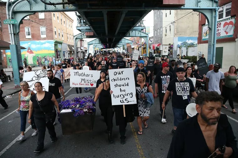Marchers make their way up Kensington Avenue during the "March in Black" on International Overdose Awareness Day in Philadelphia, PA on August 31, 2017.