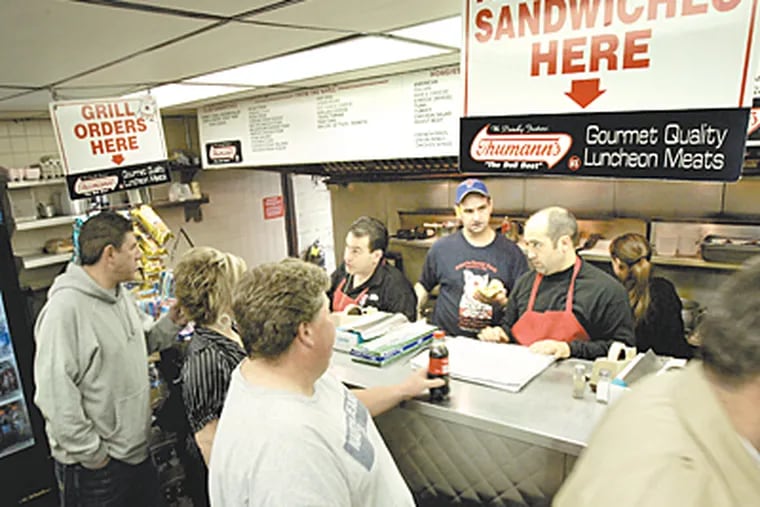 Customers line up to place their orders at John's Roast Pork at 14 E. Snyder Ave in Philadelphia. John Bucci Jr. (dark hair) takes an order. (Laurence Kesterson / Inquirer)