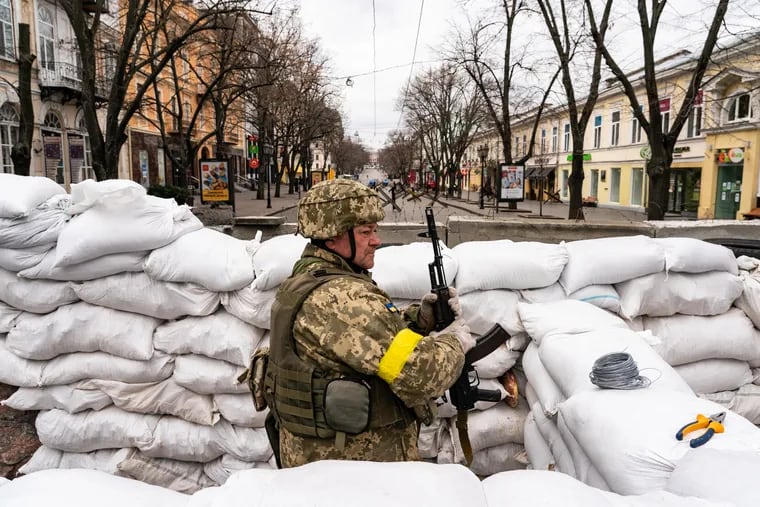 A Ukrainian soldier stands guard among sandbags in downtown Odessa on Saturday.