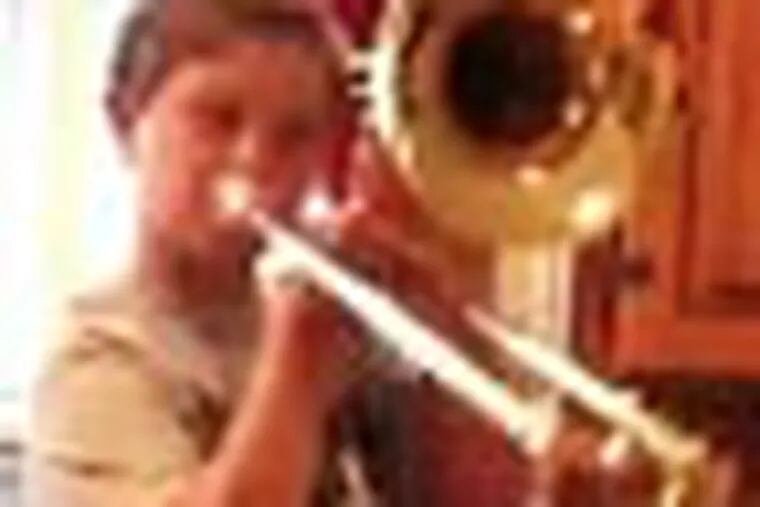 Aidan Milligan playing his trombone (it was stolen). He is shown in a video frame capture. His trombone was stolen Thursday but Phila. Orchestra is giving him a new one.