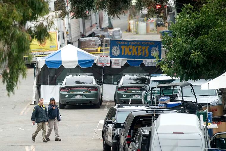 In this July 29, 2019 file photo FBI personnel pass a ticket booth at the Gilroy Garlic Festival in Calif., the morning after a gunman killed multiple people and wounded over a dozen others. A law enforcement official identified the gunman as Santino William Legan. Legan killed himself, according to a finding by the Santa Clara County coroner's office that contradicts earlier police accounts that officers fired the fatal shot.