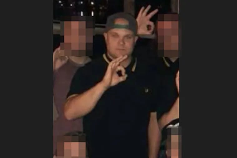 Bruce McClay Jr. makes the "OK" hand sign with other men. The hand symbol, typically seen as an innocuous gesture to signal one understands a message, has been coopted and spread by internet trolls in recent years to refer — ironically or otherwise — to white supremacy. The gesture gained gravity when a self-described racist charged with killing 51 people in a New Zealand mosque in March openly made the hand sign in court.