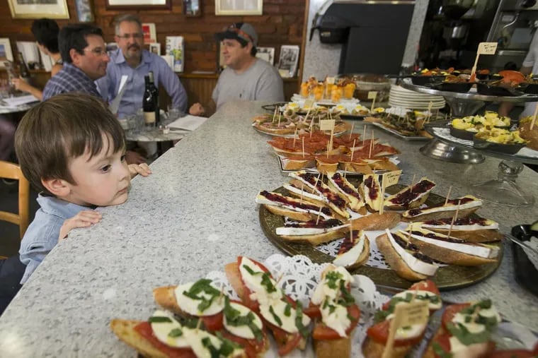 Caf&#0233; Lutecia, a longtime breakfast-lunch spot in Fitler Square, has begun serving Basque-French tapas dinners on Tuesdays only. Ogden Snow, 3, looks over the evening's offerings of small plates of appetizers on the wraparound counter.