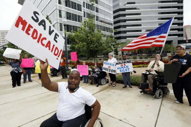 Mario Henderson leads chants of “save Medicaid” as other social service activists, Medicaid recipients and their supporters stage a protest outside the building that houses the offices of U.S. Sen. Thad Cochran, R-Miss..