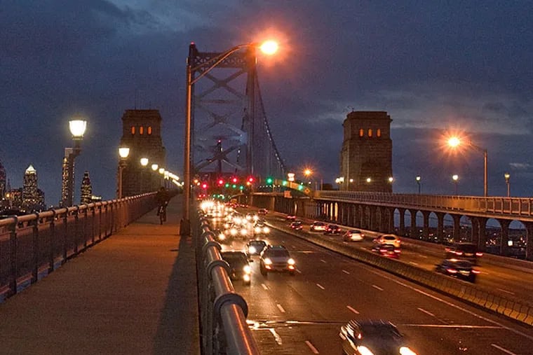 Vehicles traveling to New Jersey at dusk (headlights on left side) on the Ben Franklin Bridge. (David M Warren / Staff Photographer)