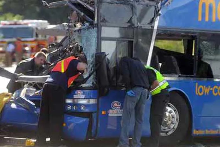 PETER CHEN / Syracuse (N.Y.) Post-Standard Onondaga County, N.Y., authorities investigate the fatal bus crash on Onondaga Parkway at the railroad bridge in Syracuse. Four people traveling from Philadelphia were killed.