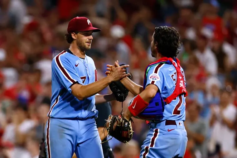 Aaron Nola is congratulated by catcher Garrett Stubbs after getting the final out for a complete game five hit shutout in a game against the Cincinnati Reds at Citizens Bank Park on August 25, 2022 in Philadelphia, Pennsylvania. The Phillies defeated the Reds 4-0. (Photo by Rich Schultz/Getty Images)
