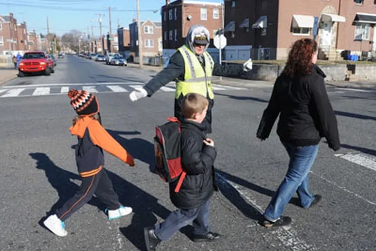 Elizabeth Biddle, 53, helps about 500 kids a day cross the street at Cottage Street and Bleigh Avenue, in Holmesburg.  Biddle, who's done the job since 1980, is one of the city's longest-service crossing guards. (Sarah J. Glover / Staff Photographer)