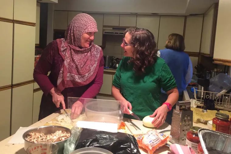 Teresa Hadjali (left) and Meredith Barber, of a Philadelphia-area chapter of Sisterhood of Salaam Shalom, prepare a kosher and halal meal to donate to Philadelphia Interfaith Hospitality Network, which often serves Muslim families.