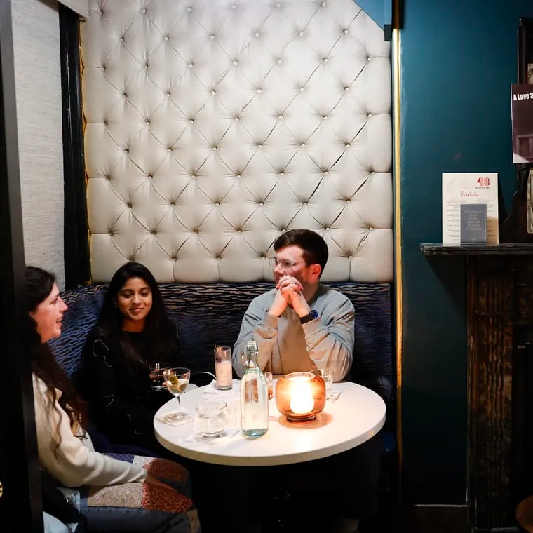 Jenna Shelby-Glick (left), Spoorthi Sampath (center), and Forrest Beaulieu sit in corner table at the 48 Record Bar, a vinyl-centric cocktail bar in Old City.