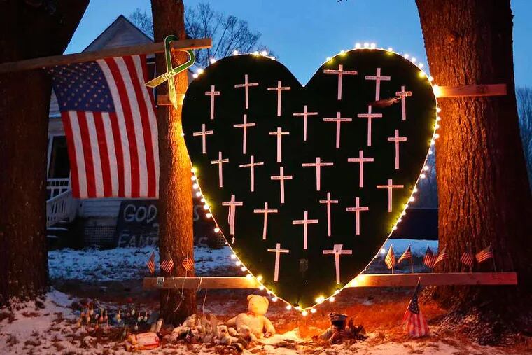 A makeshift memorial with crosses for the victims of the Sandy Hook massacre stands outside a home in Newtown, Conn., Saturday, Dec. 14, 2013, the one-year anniversary of the shootings.  (AP Photo/Robert F. Bukaty)