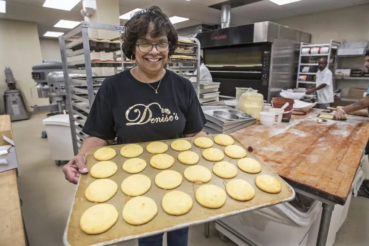 Denise Gause with a tray  of treats waiting to be iced in the baking area of her bakery on 22nd Street.