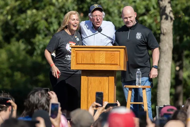 The U.S. Senator from Vermont, Bernie Sanders, center, takes the stage at a rally in support for workers with Sara Nelson, left ,head of the Association of Flight Attendants, and Sean O'Brien, President of the International Brotherhood of Teamsters, on Aug. 20, 2022.